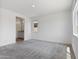 Spacious main bedroom with neutral carpet, bright light, and an ensuite bathroom entrance at 3847 S 63Rd Dr, Phoenix, AZ 85043