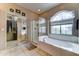 A bathroom features a glass shower stall, a garden tub under an arched window, and a closet at 4328 W Judson Dr, New River, AZ 85087