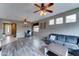Bright living room featuring hardwood floors, ceiling fans, and a gray couch at 4328 W Judson Dr, New River, AZ 85087