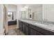 Bathroom featuring double granite vanity, stylish mirrors, and views into an adjacent bedroom at 4353 E Erie St, Gilbert, AZ 85295