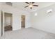 Spacious bedroom featuring neutral carpeting, a ceiling fan, closet and attached bathroom access at 4353 E Erie St, Gilbert, AZ 85295