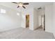 Spacious bedroom featuring neutral carpeting, a ceiling fan, walk-in closet and attached bathroom access at 4353 E Erie St, Gilbert, AZ 85295