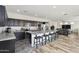 Spacious kitchen featuring an island with bar stools, dark cabinetry, flowing into the dining and living areas at 4353 E Erie St, Gilbert, AZ 85295