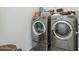Bright laundry room with stainless steel washer and dryer and convenient shelving at 4353 E Erie St, Gilbert, AZ 85295
