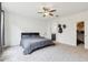 Main bedroom featuring carpet floors, a ceiling fan, and a doorway to an ensuite bathroom at 4353 E Erie St, Gilbert, AZ 85295
