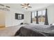 Comfortable main bedroom featuring plush carpeting, ceiling fan, and a television with gray drapes on the windows at 4353 E Erie St, Gilbert, AZ 85295