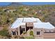 Aerial view of a home with a flat white roof surrounded by desert landscape and mountain views at 5520 E Desert Forest Trl, Cave Creek, AZ 85331