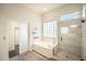 Bright bathroom with a soaking tub, a glass-enclosed shower, and neutral tile at 5520 E Desert Forest Trl, Cave Creek, AZ 85331