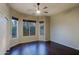 An empty room with a ceiling fan, hardwood floors, and large windows at 5520 E Desert Forest Trl, Cave Creek, AZ 85331