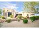 Beige stucco home with desert landscaping featuring gravel, greenery and a retaining wall at 5520 E Desert Forest Trl, Cave Creek, AZ 85331