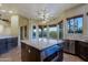Kitchen with island with marble countertop, wine cooler, and large windows to the backyard at 5520 E Desert Forest Trl, Cave Creek, AZ 85331