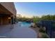 Backyard pool with rock waterfall, and desert landscaping can be seen from the covered patio with ceiling fan at 5520 E Desert Forest Trl, Cave Creek, AZ 85331