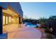 Backyard patio leads to pool with rock waterfall, and desert landscaping at twilight at 5520 E Desert Forest Trl, Cave Creek, AZ 85331