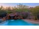Backyard swimming pool with rock waterfall, mature desert landscaping, and a mountain view at 5520 E Desert Forest Trl, Cave Creek, AZ 85331