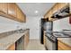 Kitchen with tiled floors, wood cabinets, black appliances, and laminate counters at 600 S Dobson Rd # 178, Mesa, AZ 85202