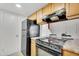 Kitchen with tiled floors, wood cabinets, laminate counters, and black appliances at 600 S Dobson Rd # 178, Mesa, AZ 85202