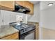 Kitchen featuring tile floors, wood cabinets, laminate counters, and black appliances at 600 S Dobson Rd # 178, Mesa, AZ 85202