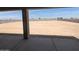 Large, unfinished backyard offers vast potential for customization, viewed from a covered patio area at 6262 S Dean Rd, Buckeye, AZ 85326