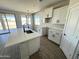 Bright kitchen with white cabinets, a quartz island, and modern lighting at 6262 S Dean Rd, Buckeye, AZ 85326