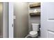 Half bath featuring a modern toilet and wood shelves at 651 W Cobblestone Dr, Casa Grande, AZ 85122