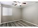Bedroom with wood-look floors, window, and ceiling fan at 651 W Cobblestone Dr, Casa Grande, AZ 85122