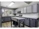 Updated kitchen with grey cabinetry, stainless steel appliances, patterned backsplash, and kitchen island at 651 W Cobblestone Dr, Casa Grande, AZ 85122