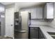 Stainless steel refrigerator next to the door, with gray cabinets and countertops at 651 W Cobblestone Dr, Casa Grande, AZ 85122