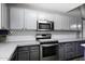 Close-up of updated kitchen with stainless steel oven and microwave, and gray cabinets at 651 W Cobblestone Dr, Casa Grande, AZ 85122