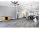 Open-concept living room with modern wood-look floors, a ceiling fan, and easy access to the dining area at 651 W Cobblestone Dr, Casa Grande, AZ 85122