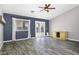 Bright living room with wood-look flooring, a ceiling fan, and a sliding glass door leading to the backyard at 651 W Cobblestone Dr, Casa Grande, AZ 85122