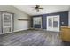 Spacious living room with wood-look floors, a ceiling fan, and a sliding glass door to the outdoor space at 651 W Cobblestone Dr, Casa Grande, AZ 85122