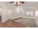Bright living room featuring neutral carpet, tile flooring, and shuttered windows at 6787 W Saddlehorn Rd, Peoria, AZ 85383