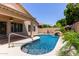 Beautiful backyard pool with waterfall feature and covered patio area for relaxation and entertainment at 6787 W Saddlehorn Rd, Peoria, AZ 85383