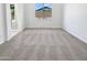 Bright bedroom featuring neutral carpet, white walls, and a view of the backyard at 7316 E Fledgling Dr, Scottsdale, AZ 85255