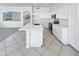 Bright kitchen boasts all-white cabinets, stainless appliances, large island, and easy access to living area at 7316 E Fledgling Dr, Scottsdale, AZ 85255