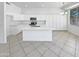 Bright kitchen features all-white cabinets, stainless appliances, large island, and tile flooring at 7316 E Fledgling Dr, Scottsdale, AZ 85255