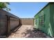 View of gravel backyard featuring a green painted shed, privacy walls, and minimal desert landscaping at 759 W Los Lagos Vista Ave, Mesa, AZ 85210