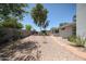 View of gravel backyard featuring desert landscaping, stone pathways, mature trees, and privacy walls at 759 W Los Lagos Vista Ave, Mesa, AZ 85210