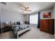 Comfortable bedroom with ceiling fan, window with blinds, and wood dresser for ample storage at 759 W Los Lagos Vista Ave, Mesa, AZ 85210