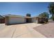 A spacious, single-story brick home featuring a three-car garage and low-maintenance desert landscaping at 759 W Los Lagos Vista Ave, Mesa, AZ 85210
