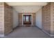 Inviting covered entryway featuring brick columns and a wood front door with decorative glass panels at 759 W Los Lagos Vista Ave, Mesa, AZ 85210