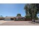 Charming single-story brick home featuring a lush front yard, mature trees and a two-car garage at 759 W Los Lagos Vista Ave, Mesa, AZ 85210