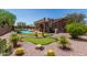 Inviting backyard showcasing a pool, putting green, desert landscaping, and elevated patio with a spiral staircase at 7762 E Russell Cir, Mesa, AZ 85207