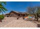 Backyard features an inviting pool, covered patio, brick-paved walkway, and a serene desert landscape at 7762 E Russell Cir, Mesa, AZ 85207