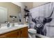 Bathroom features a stylish vanity, commode, and a shower curtain with a Scottish Highland cow theme at 7762 E Russell Cir, Mesa, AZ 85207