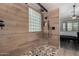 Stylish shower with wood-look tile, glass block window, and modern fixtures at 7762 E Russell Cir, Mesa, AZ 85207