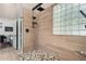 Beautiful shower with wood-look tile, glass block window, and modern fixtures at 7762 E Russell Cir, Mesa, AZ 85207