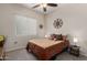 Cozy bedroom featuring a comfortable queen bed, ceiling fan and warm, neutral decor, with natural light from the window at 7762 E Russell Cir, Mesa, AZ 85207