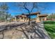 Community entrance with stone-accented architecture, a tile roof, and desert landscaping at 7762 E Russell Cir, Mesa, AZ 85207