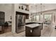 Well-lit kitchen with a stainless steel refrigerator, island with breakfast bar, and backyard views at 7762 E Russell Cir, Mesa, AZ 85207
